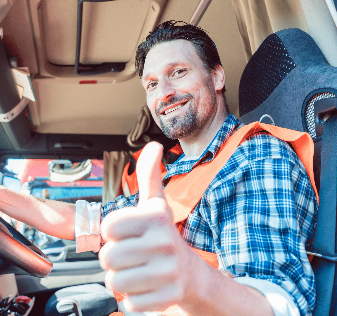 Усміхнений водій вантажівки в сигнальному жилеті, з піднятими вгору великими пальцями за кермом. Підтримка професійного митного оформлення та транспортно-експедиторських послуг